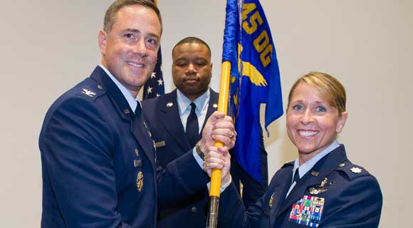 Col. Thomas G. Falzarano, 45th Operations Group commander, presents Lt. Col. Monique Delauter, 1st Range Operations Squadron commander, with the 1st ROPS guidon during a change of command ceremony last week at the Cape Canaveral Air Force Station Morrell Operations Center. (U.S. Air Force image by Matthew Jurgens)