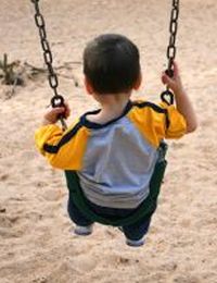 Boy On A Swing At The Park