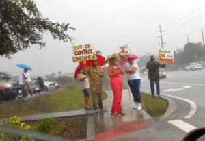 Local activists braved torrential rain and gathered to protest at the IRS office in Melbourne.