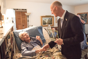 Gov. Scott Hands the Great Floridian Award to Patrick Smith in his Merritt Island home. Smith wrote historic novels about Florida and Indian tribes.