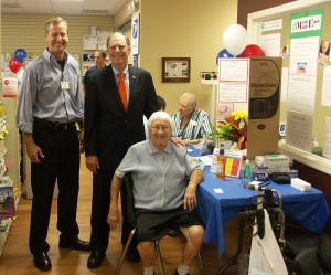 Mark Hobbs (left), pharmacist and owner of Hobbs Pharmacy, and Bill Posey, U.S. Representative for Florida's 8th congressional district, chat with a patient at a Script Your Future event hosted by Hobbs Pharmacy.