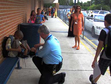 Dr. Miller assists a student with his shoe during dismal. (Image for SpaceCoastDaily.com)