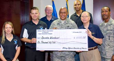 Ernie Joy, second from right, President of the Military Officers Association of America, Cape Canaveral Chapter, and Senior Master Sgt. Galen Zalace, 45th Civil Engineer Squadron, second from left, present a $6,000 check in support of Operation Warmheart. (Image for Space Coast Medicine & Active Living)