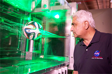 Dr. Rabi Mehta uses smoke and lasers to inspect the flow pattern around an Adidas Brazuca football. (NASA.gov Image)