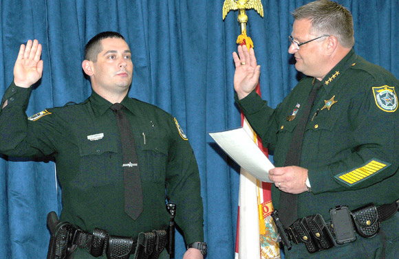 Brevard County Sheriff Wayne Ivey, right, swears in Cpl. (Ret) Robert Smith of the United States Marine Corps. In May 2008, while on military patrol in Iraq in the city of Fallujah, Robert’s Unit encountered an IED that exploded, injuring several in the unit including Robert, who lost his right leg. (BCSO image)