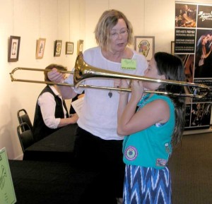 Cindy Johnson, Brevard County Schools Music Resource Teacher, explains how to play the trombone, in Brevard Symphony Orchestra’s “Instrument Petting Zoo.” Nancy Lundell image) 