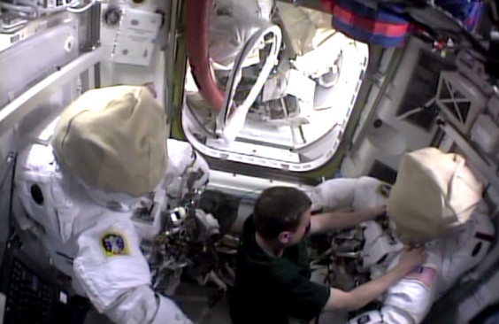 Flight Engineer Reid Wiseman works with a spacesuit in the equipment lock of the International Space Station's Quest airlock. (NASA.gov image)