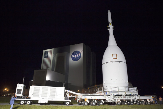 At NASA's Kennedy Space Center in Florida, the agency's Orion spacecraft pauses in front of the spaceport's iconic Vehicle Assembly Building as it is transported to Launch Complex 37 at Cape Canaveral Air Force Station. After arrival at the launch pad, United Launch Alliance engineers and technicians will lift Orion and mount it atop its Delta IV Heavy rocket. (NASA.gov image)