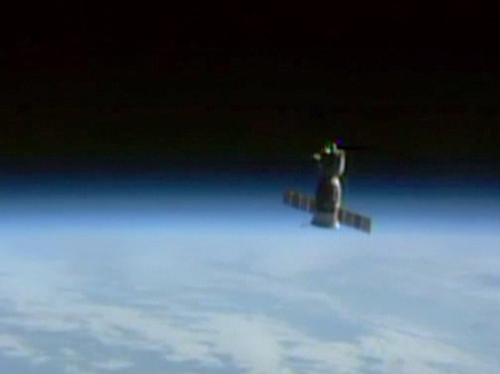 The Soyuz TMA-13M is seen intersecting Earth’s limb several minutes after undocking from the International Space Station. (NASA TV image)