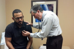 Dr. Mark Caruso examines patient Emanuel Vega during an annual physical exam at Baptist Health Primary Care in Miami (Photo by Jenny Gold/KHN).