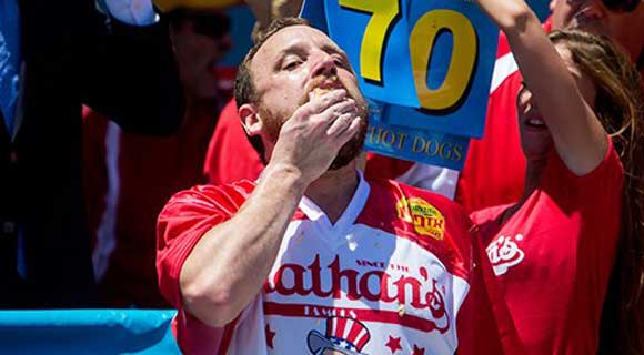 Joey "Jaws" Chestnut beat his own record in regaining the Mustard Yellow International Belt on Monday, downing a stomach-churning 70 hot dogs and buns to top Matt "The Megatoad" Stonie at the annual July Fourth eating contest.